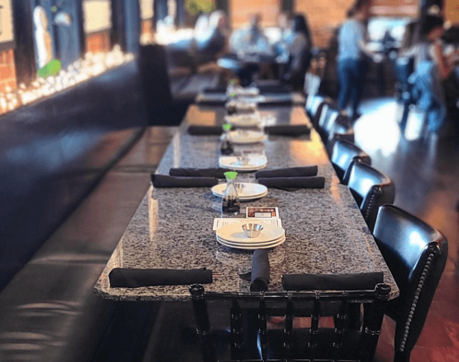 Interior of Yosake Restaurant in downtown Wilmington, North Carolina, featuring warm lighting, exposed brick walls, and modern Asian-inspired décor.