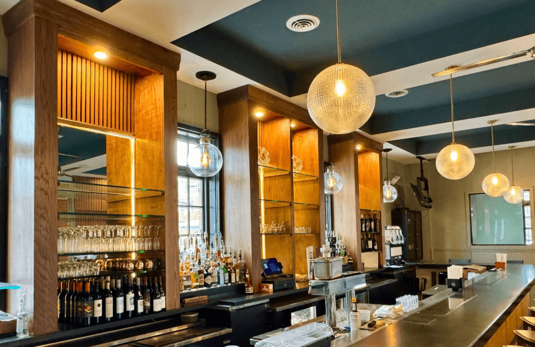 Interior of The George Restaurant in Wilmington, NC, with warm lighting, river-view windows, and a refined coastal dining ambiance.